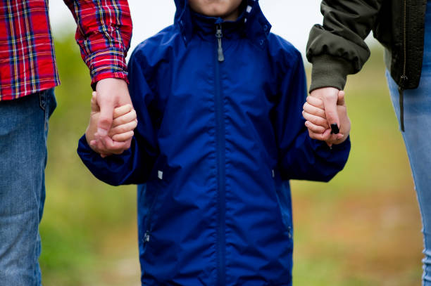 istock parents hold son by hands, without face, close-up 1178610898