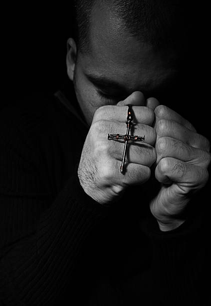 istock Manding Holding Cross Praying 117861218