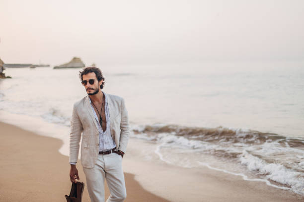 istock Fashionable guy taking a walk on the beach 1178613486