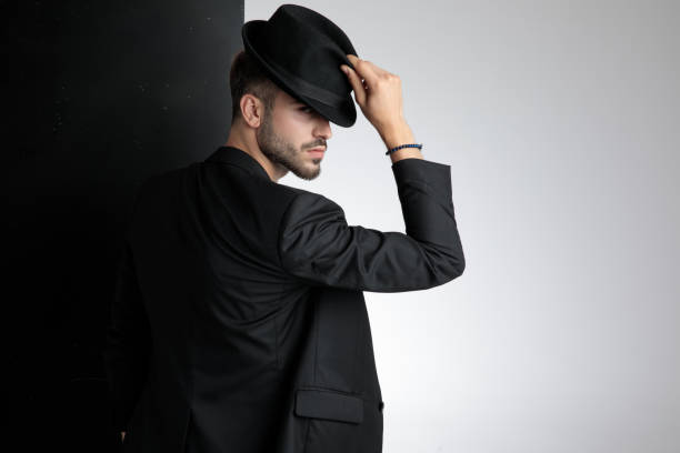 istock polite young man holding black hat in studio 1178615008