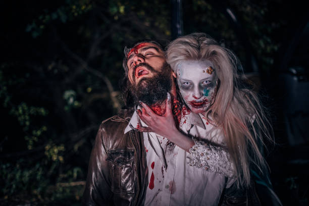 Undead zombie woman biting man Woman dressed as witch biting man at night. Zombie concept male vampire biting his victim stock pictures, royalty-free photos & images