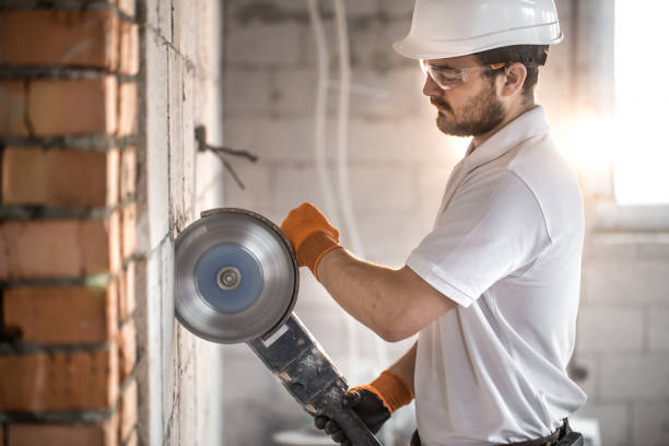 istock The industrial Builder works with a professional angle grinder to cut bricks and build interior walls. Electrician. 1178616486