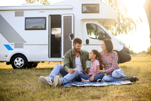 Family camping in a recreational vehicle. About 30 years old parents and a 8 years old daughter, all Caucasian people.