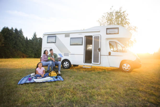 Family camping Family camping in a recreational vehicle. About 30 years old parents and a 8 years old daughter, all Caucasian people. camper trailer photos stock pictures, royalty-free photos & images
