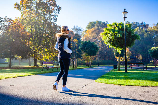 istock Middle-aged woman walking in city park 1178620849
