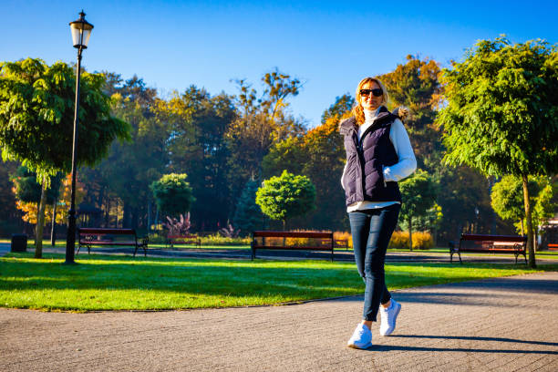 istock Middle-aged woman walking in city park 1178620882