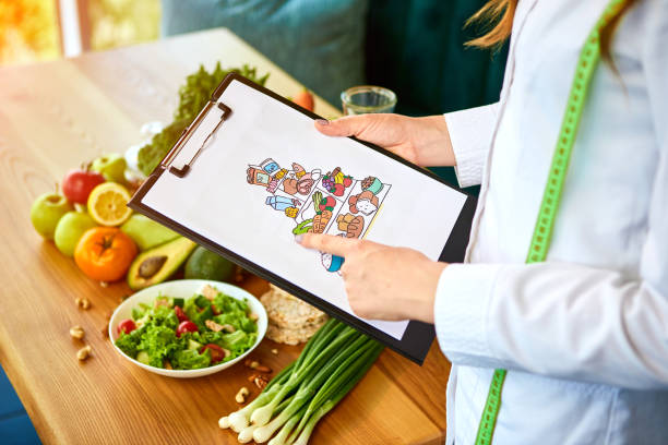 istock Holding schematic meal plan for diet with various healthy products on the background. Weight loss and right nutrition concept. Eating food pyramid 1178624286