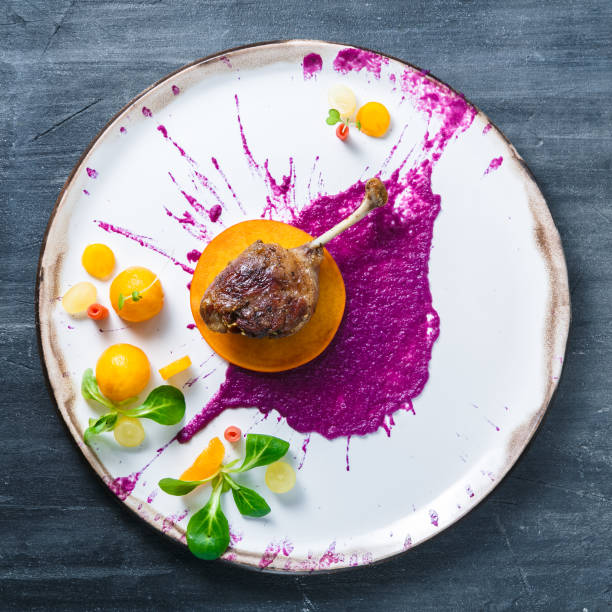 istock Duck leg confit with cabbage puree and persimon on white plate, restsurant meal 1178624402
