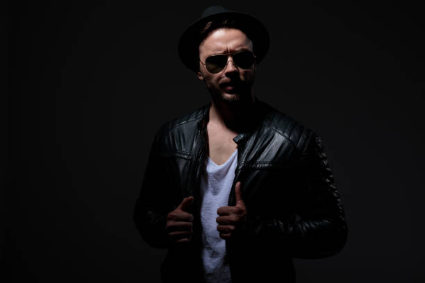 istock dramatic young man wearing leather jacket on grey background 1178624917