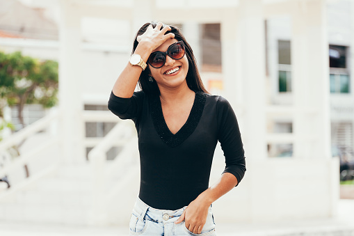 Portrait of young beautiful woman wearing sunglasses in the city