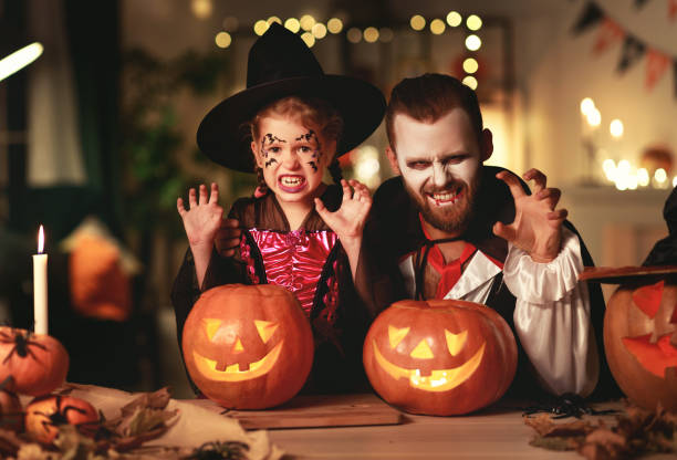pai da família feliz e filha da criança nos trajes e na composição em halloween - 11917 - fotografias e filmes do acervo