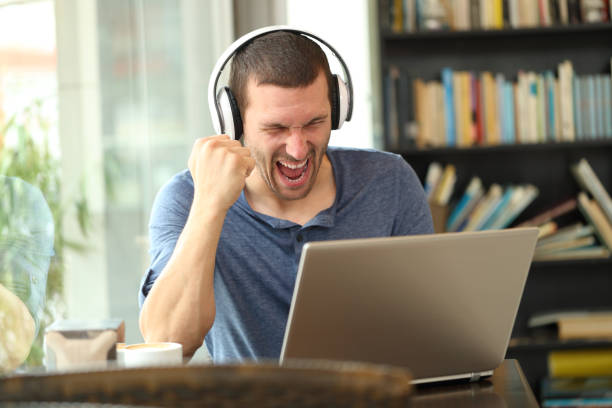 istock Excited man wearing headphones checking laptop 1178627726