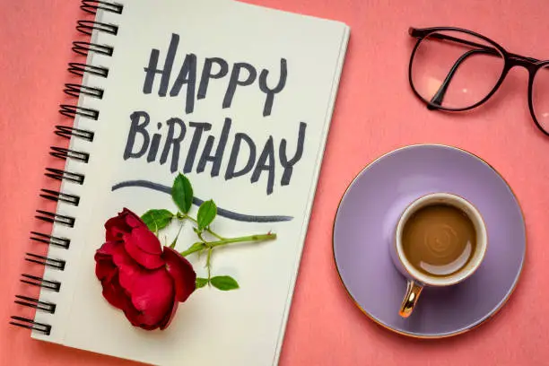 Happy Birthday  greeting card - handwriting in a sketchbook, flat lay with coffee, red rose and glasses