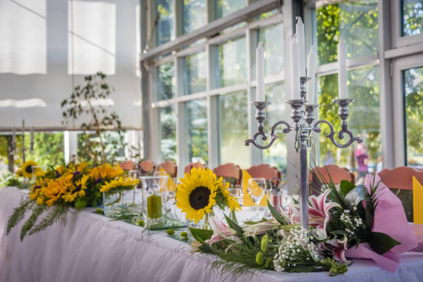 Decorated wedding table with sunflower bouquet candles in silver candlestick.