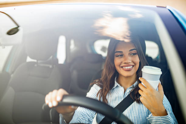 istock Woman sipping a coffee while driving a car 1178642134
