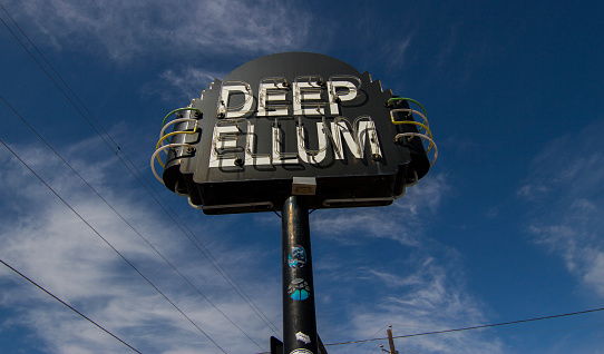 12/12/2023: Amboy, California, USA. Vintage neon sign of Roy's motel and cafe on Route 66 with vintage car. Sunny day.