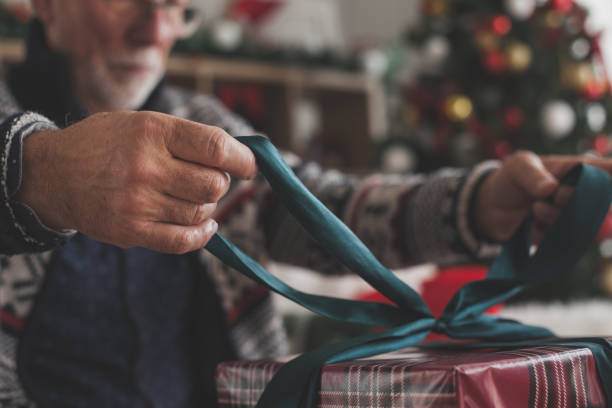 istock Close up of a man tying a bow on a Christmas gift 1178664892