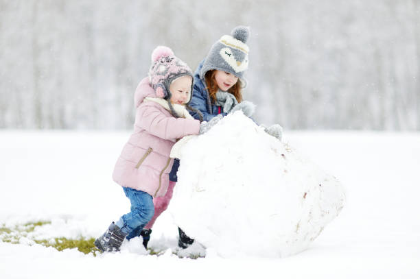 istock Two funny adorable little sisters in winter park 1178667331
