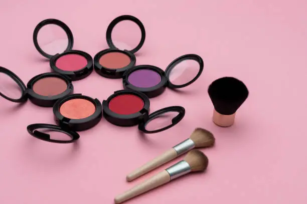 Photo of Makeup applicators near colorful rouges