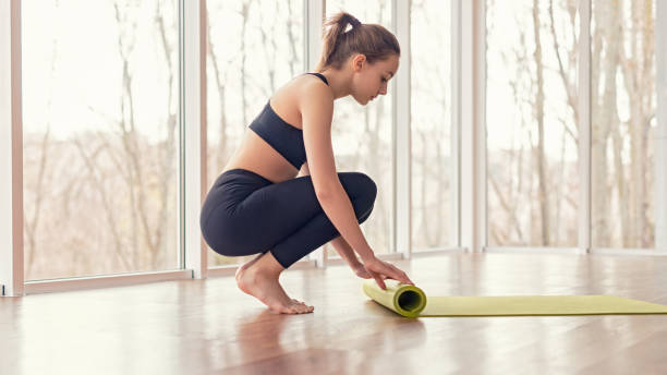 istock Barefoot woman rolling mat after yoga training 1178672357