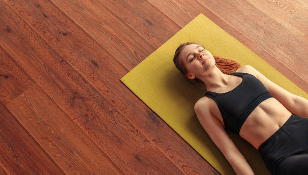 istock Peaceful woman meditating while lying down on floor 1178672372