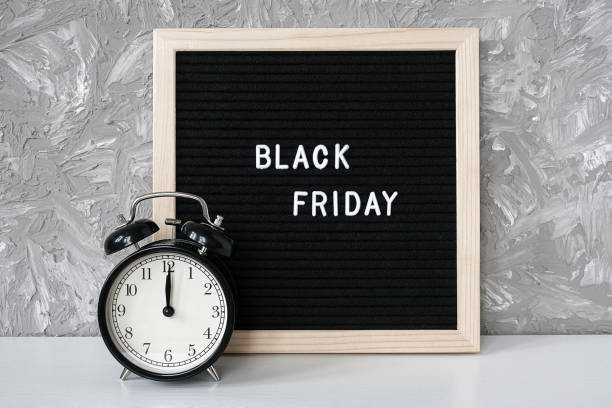 istock Text Black friday on black letter board and alarm clock on table against grey stone background. Concept Black friday , season sales time 1178677642