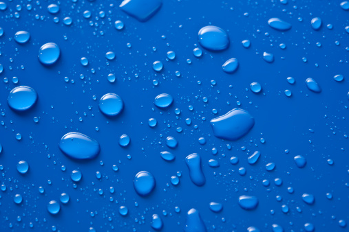 various sized water droplets against a gloss blue background.