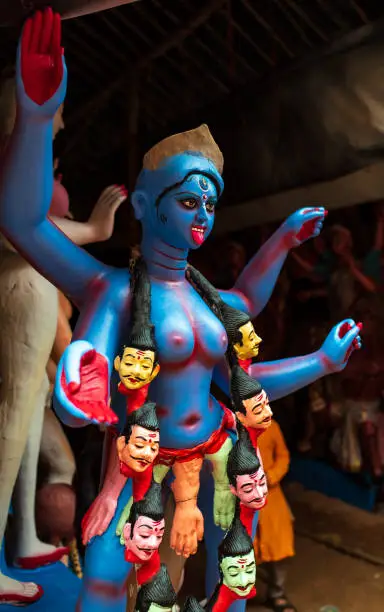 Blue idol of goddess Kali wearing a necklace made of Heads of demons. Sculptor of a Hindu god.