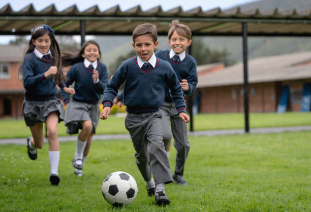 Happy kids playing soccer at the school Happy group of kids playing soccer on their break at the school - education concepts recess soccer stock pictures, royalty-free photos & images