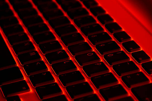 istock Close up view of a modern laptop computer keyboard keys. Soft lightning in red tones. Pc computer keyboard close up 1178695046