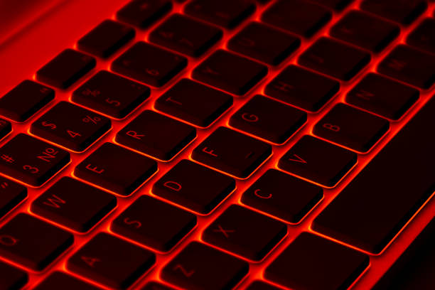 istock Close up view of a modern laptop computer keyboard keys. Soft lightning in red tones. Pc computer keyboard close up 1178695059
