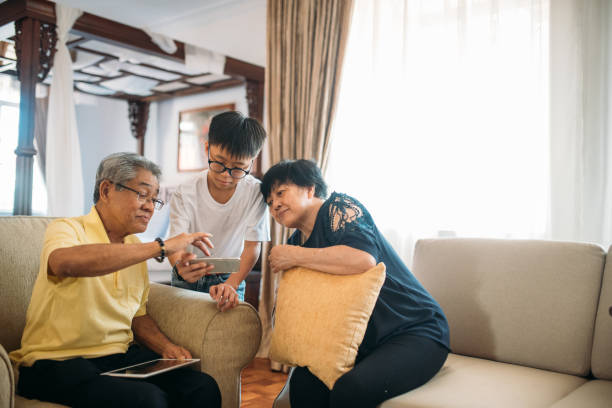 istock Boy using digital tablet with his grandparent in living room 1178696102
