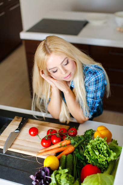 istock Beautiful young woman preparing fresh vegetable salad 1178701089