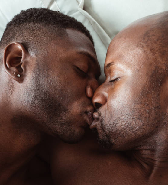 couples homosexuels embrassant dans le lit - gay man homosexual sex men photos et images de collection
