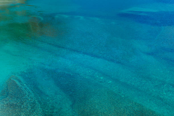 A horizontal and abstract view of a clear and turquoise mountain lake