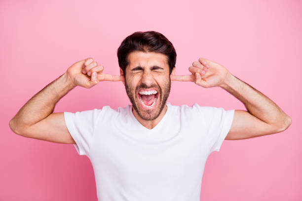 Stop irritating me. Portrait of upset negative emotions middle eastern man close cover ears index finger dont want listen argument with his wife wear trend clothes isolated pastel color background Stop irritating me. Portrait of upset negative emotions middle eastern man close cover ears index finger dont want listen argument, with his wife wear trend clothes isolated pastel color background man closing ears photos stock pictures, royalty-free photos & images
