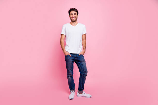 매력적인 긍정적 인 마초 남자 아라비아 사람의 전체 길이 사진은 파스텔 색상 배경을 통해 고립 된 그의 여자 친구 착용 트렌드 현대 의상과 봄 휴가 산책을 가지고 - t shirt white men jeans 뉴스 사진 이미지