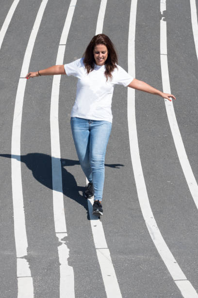 istock Woman balancing on a white line painted on the floor. 1178713321