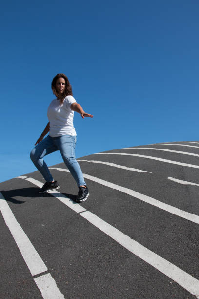 istock Confident woman posing over asphalt floor with white stripes 1178713379