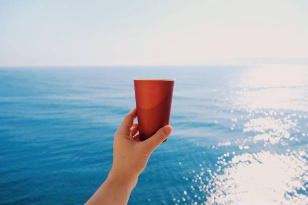 glass of coffee in hand on a background of the sea. - 4622 imagens e fotografias de stock