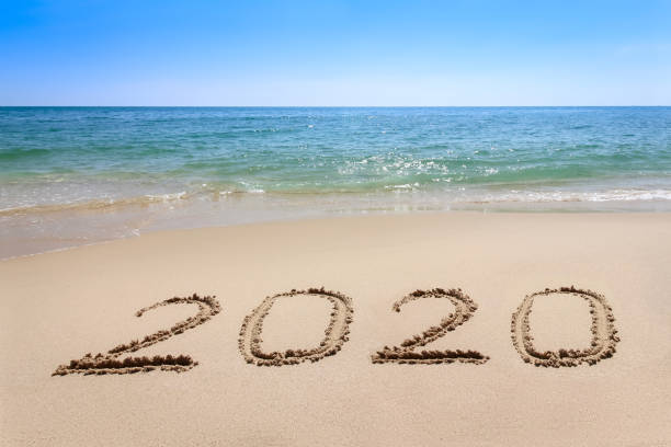 istock Year 2020 written at the sand beach with sea wave water 1178721724