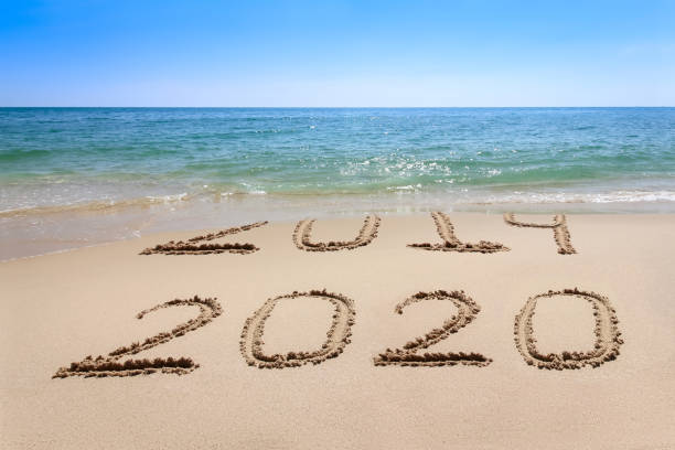 istock Year 2020 written at the sand beach with sea wave water 1178721725