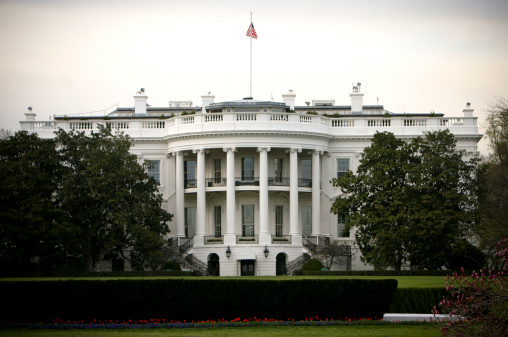 American flag against the background of the White House in Washington DC, Symbol of the United States of America. US Army Veterans Day, Memorial Day. Patriotism of the United States of America. Cover for greeting card National Day.