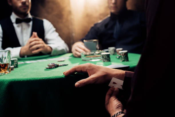 istock cropped view of man cheating while playing poker on black with smoke 1178724345