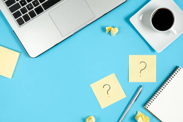 istock Asking, Decisions. Question mark on sticky notes, notebook, cup coffee, laptop and pen on blue background. FAQ concept. Working with clients. Troubles in work. Flat lay, top view, copy space 1178725386