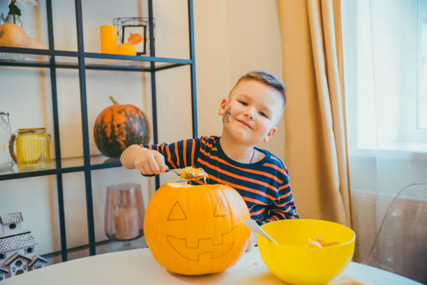 istock little boy makes halloween pumpkin head at home holidays preparation 1178725549