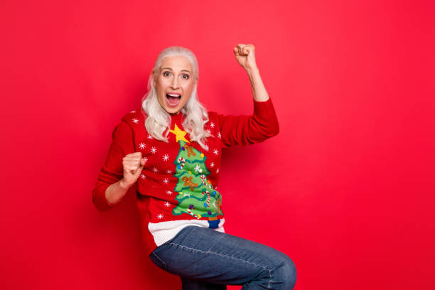 Photo of enthusiastic funky retro model granny having fun good mood gesturing raising fists up wearing jeans denim bright jumper isolated vivid color background Photo of enthusiastic funky retro model granny having fun good mood, gesturing raising fists up wearing jeans denim bright jumper isolated vivid color background christmas excitement stock pictures, royalty-free photos & images