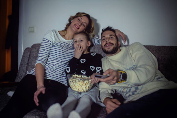 istock Family eating popcorn while watching tv at home 1178727817
