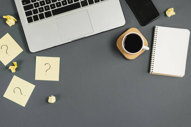 istock Question mark on sticky notes, notebook, cup coffee, phone, pen on gray background. FAQ concept. Working with clients. Troubles in work. Flat lay, top view, copy space 1178728094