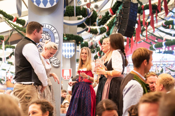 visitantes que comemoram oktoberfestfest na barraca da cerveja, munich, alemanha - lederhosen oktoberfest beer dancing - fotografias e filmes do acervo